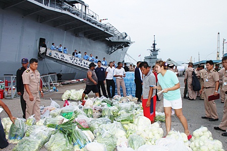 Officers, crew and civilians begin loading supplies headed for the flood stricken south.